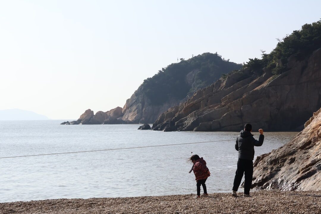 Photographer interviewing an elderly fisherman by the coast